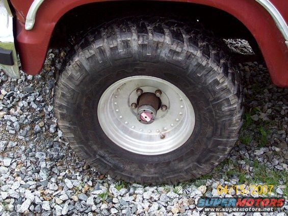Red SUV fender over a large off-road tire with a silver rim