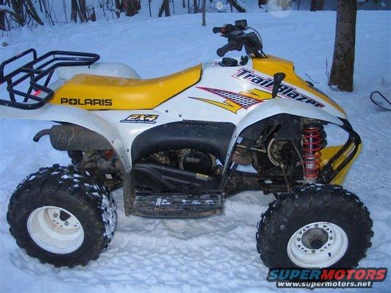 White and yellow ATV with 'Polaris' and 'Trail Blazer' decals in the snow
