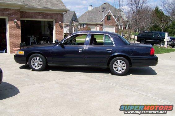 Dark blue 2003 Ford Crown Victoria sedan parked on a concrete driveway