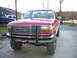 1995 Ford F-250 - A red Ford F-250 pickup truck is parked outside with a lake in the background.