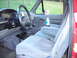 1995 Ford F-250 - The interior of a red truck shows gray cloth seats and a floor-mounted shifter.