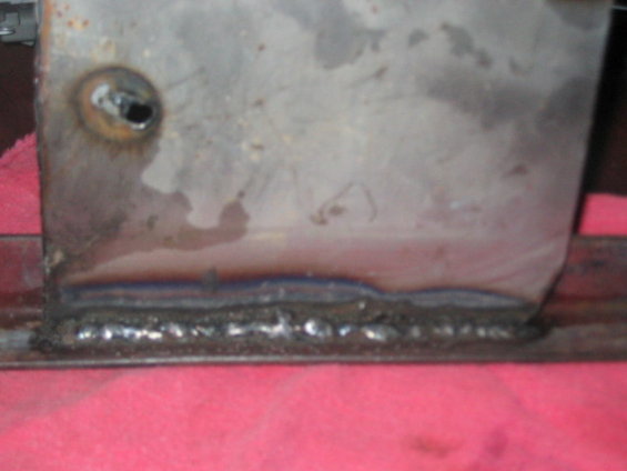 Close-up of a metal bracket with visible welds and a hole