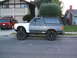 1988 Ford Bronco - This modified Ford Bronco is parked in front of a house, with another SUV visible in the driveway.