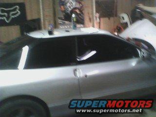 Silver coupe side view, tinted windows, Supermotors.net logo visible