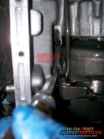 Close-up of a metal lever mechanism with red text overlay and a date stamp