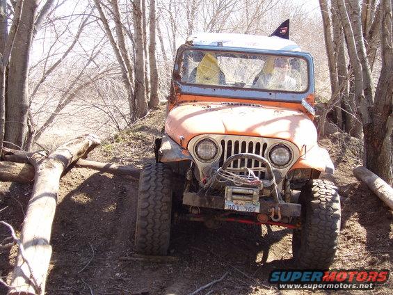 Orange off-road vehicle with winch on a dirt trail