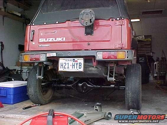Red Suzuki Samurai rear view, spare tire mount visible, Texas license plate H21-HYB