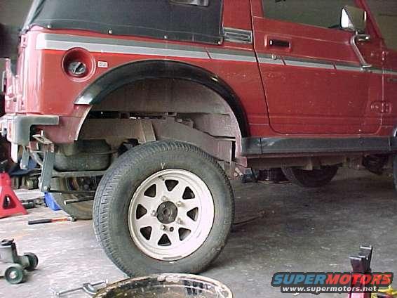 Red SUV side view, showing wheel and suspension components