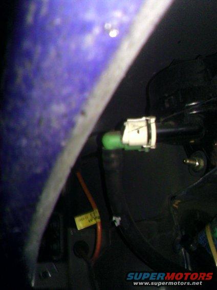Close-up of a green and white automotive electrical connector with wires