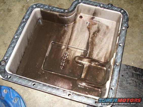 Transmission oil pan with sludge and a visible part number '428000'