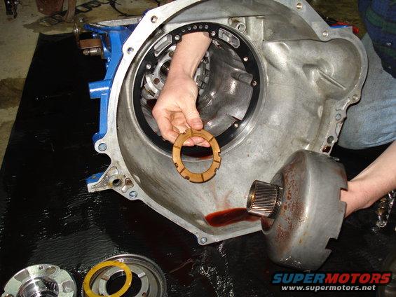 hand holding a transmission clutch pack disc inside a transmission case