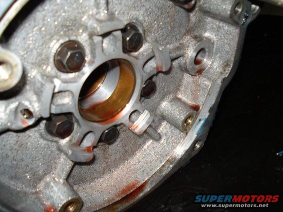 Close-up of a transmission housing with a bearing and some reddish fluid