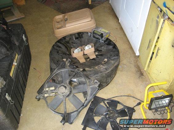 Spare tire with two mounting brackets, two radiator fans, and a center console storage unit