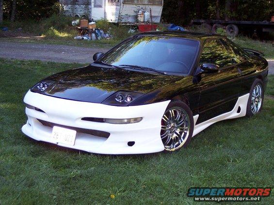 Black and white custom sports car with aftermarket body kit and chrome wheels