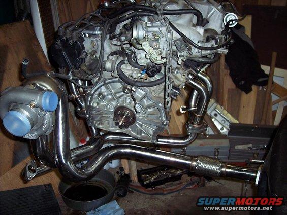 Engine block with turbocharger, chrome exhaust manifold, and flexible exhaust pipe