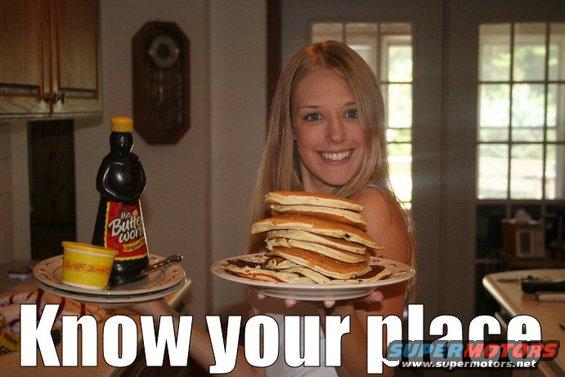 Woman holding a stack of pancakes and a bottle of syrup