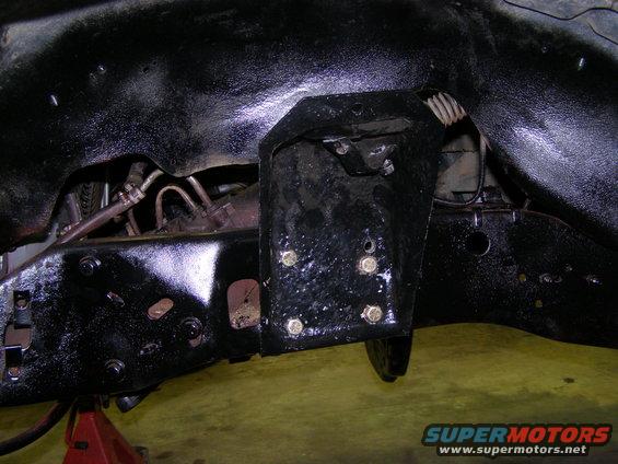 Close-up of vehicle frame with suspension bracket and bolts