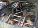 1992 Ford Mustang - The interior of a car is shown with a roll cage and the rear axle assembly.