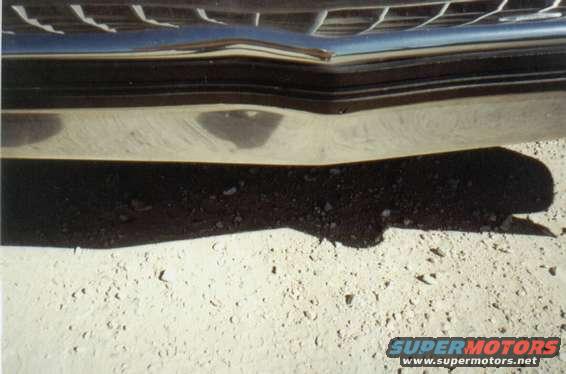 close-up of a chrome bumper and grille, with a shadow on the ground