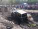 1989 Ford Bronco - Jeep Wrangler tackling a challenging mud pit during an off-road event.