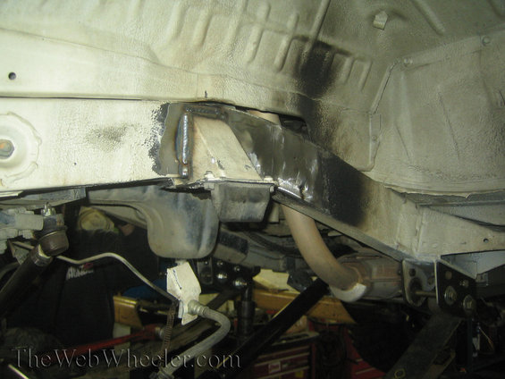 Close-up of a vehicle's frame showing recent welds and modifications to the suspension mounting points
