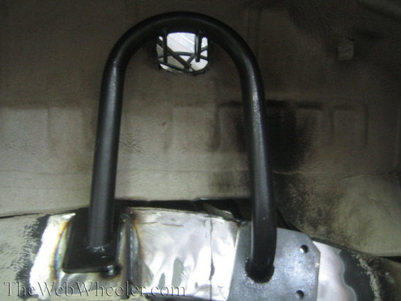Black roll cage tubing welded to vehicle frame