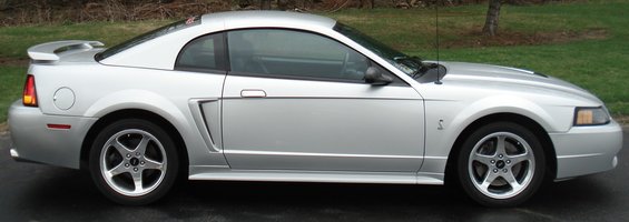 Silver coupe side view with spoiler and five-spoke wheels