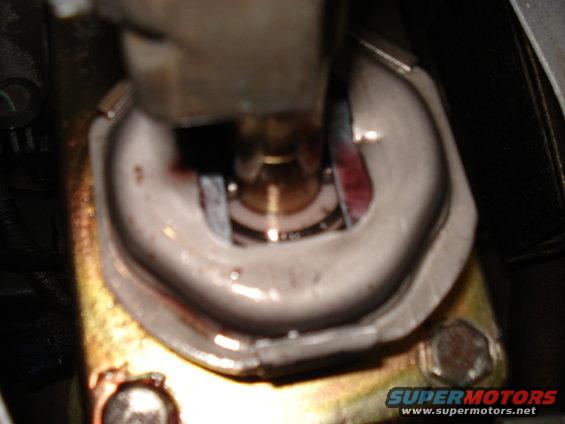 Close-up of automatic transmission shifter linkage with red fluid visible