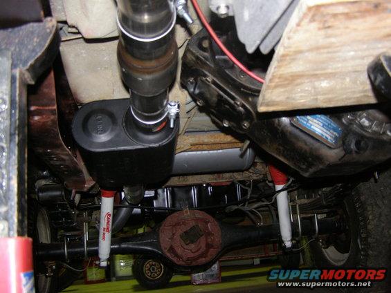 Underside view of a vehicle's exhaust, suspension, and rear axle. Rancho RS 5000 shocks are visible