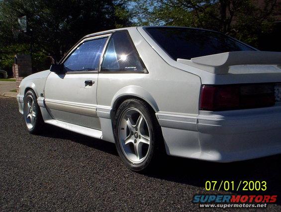 White 1991 Ford Mustang coupe with a rear spoiler, seen from the 3/4 front angle