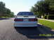 1991 Ford Mustang - Rear view of a white 1991 Ford Mustang, identifiable by its distinct body style and spoiler.