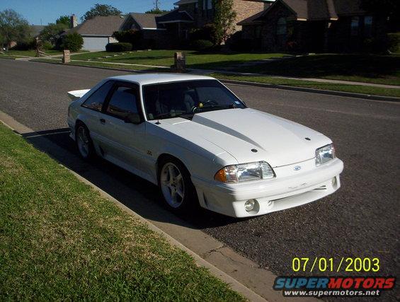 White 1991 Ford Mustang coupe parked on a residential street, viewed from the front three-quarter angle