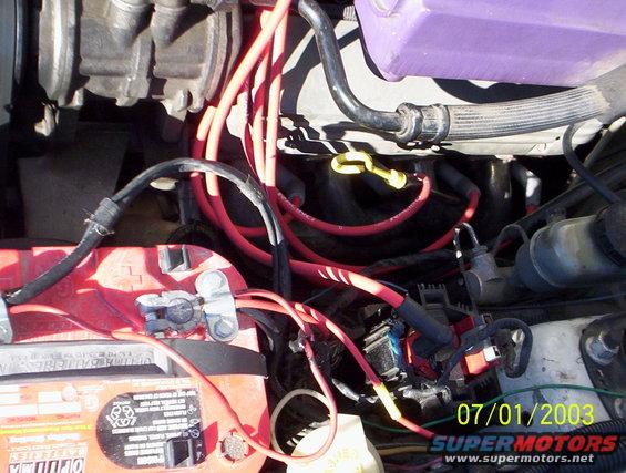 Engine bay with red spark plug wires and a purple fluid reservoir. Date stamp 07/01/2003