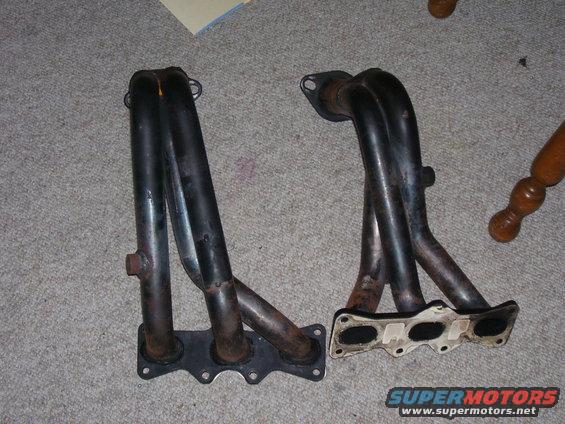 two black exhaust manifolds on a carpeted floor