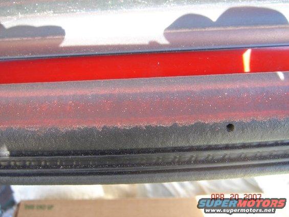 Rear bumper detail with red accent strip and black trim