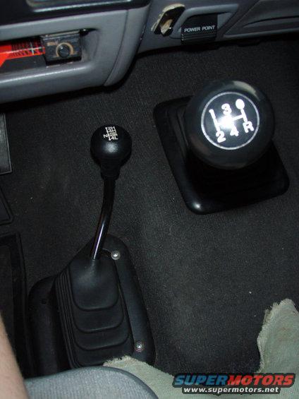Interior view of two gear shifters, one with 4-speed manual pattern, the other with 2H/4H/N/4L markings