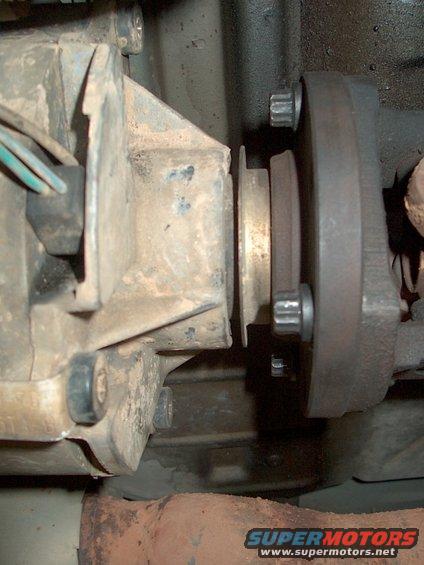 Close-up of a dirty drivetrain part with bolts and wires visible
