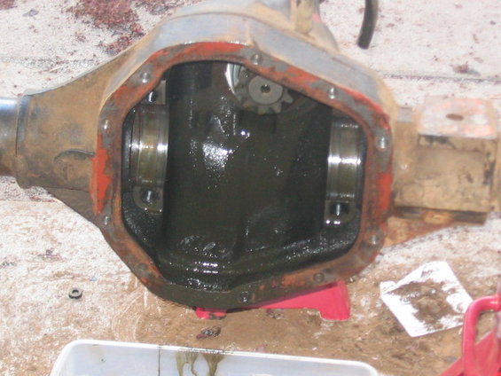 Differential housing with red paint on edges, open for inspection with dark fluid inside