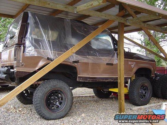 Brown 1986 Ford Bronco II with plastic sheeting, side view