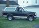 1993 Ford Bronco - This black and white Ford Bronco SUV is parked on a grassy lawn in front of a house and garage.