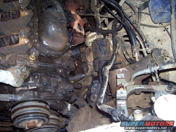 Engine bay detail showing starter motor, pulleys, and engine block