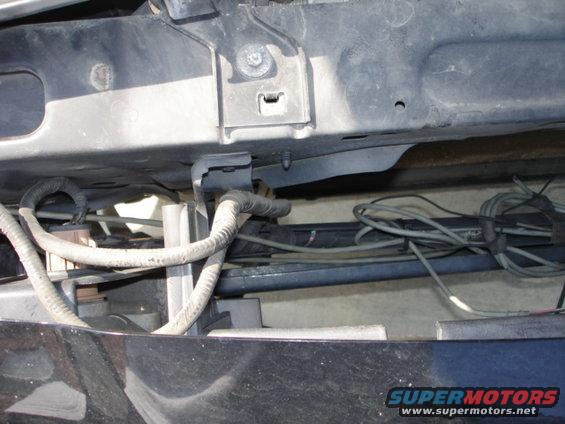Underside of a vehicle's front end, showing wiring harnesses and frame components
