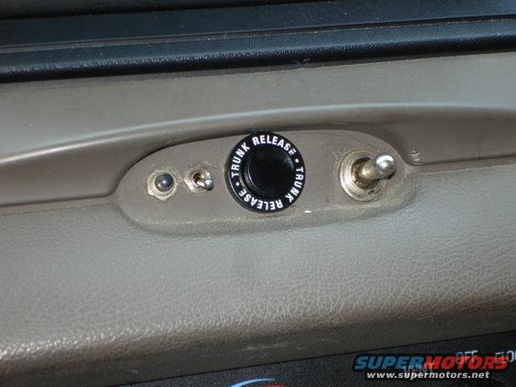 Interior dashboard with trunk release button and toggle switch