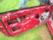1996 Ford Probe - The interior of a red car door is visible, showing its internal components and wiring.