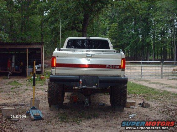 1990 Ford F-150 rear view, lifted with large tires, parked outdoors