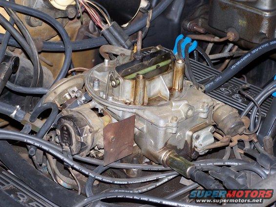 Carburetor with blue spark plug wire holders and "SUPERMOTORS" logo visible