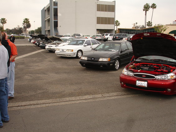 Black 1992 Ford Taurus hatchback parked in a lot, front 3/4 view. Hood is closed, wheels are visible