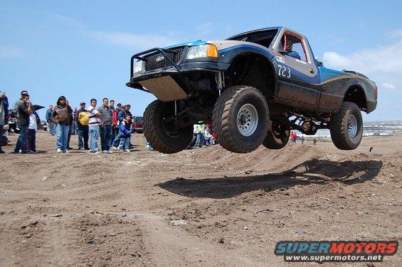 Off-road truck mid-air jump, number 723 on door