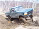 1996 Ford Bronco - Green 1996 Ford Bronco navigating a muddy off-road course with one wheel elevated.