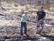 1996 Ford Bronco - Two people are in a muddy, wooded area, one holding a tow chain.
